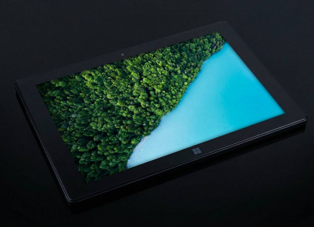 Fusion5 Pro N5 Windows tablet displaying a vibrant Full HD screen with a top-down view of a forest and blue water on a sleek black background